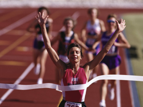 female-runner-victorious-at-the-finish-line-in-a-track-race_large